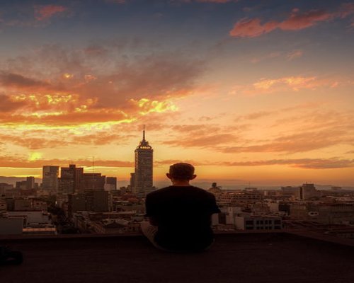 Persona relajándose en su balcón con vista a la ciudad